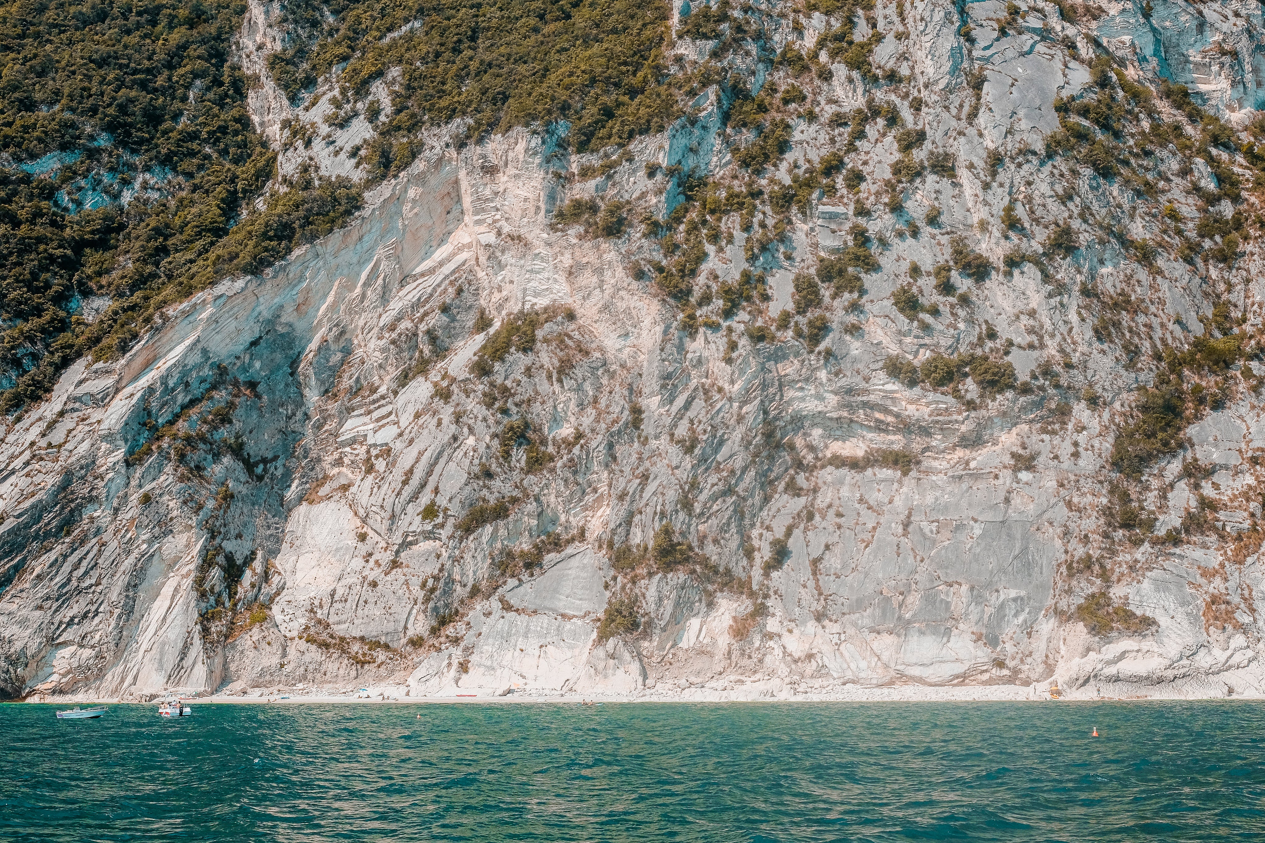Layered coastal cliffs above turquoise water in a calm nature and wellness landscape